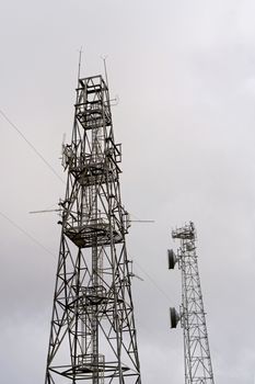 Modern technology communication towers against a bright sky