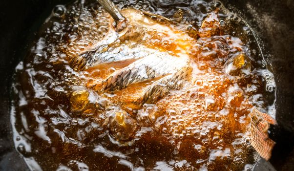 Close up of Fried fish in a frying pan.