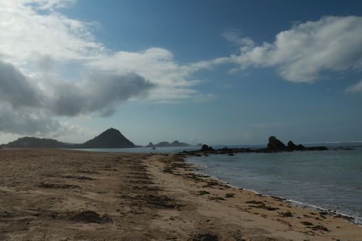 Rock formations on the beach Mandalika Kuta beach, Lombok, Indonesia. Blue sky and suuny day.