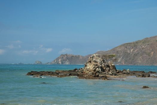 Rock formations on the beach Mandalika Kuta beach, Lombok, Indonesia. Blue sky and suuny day.