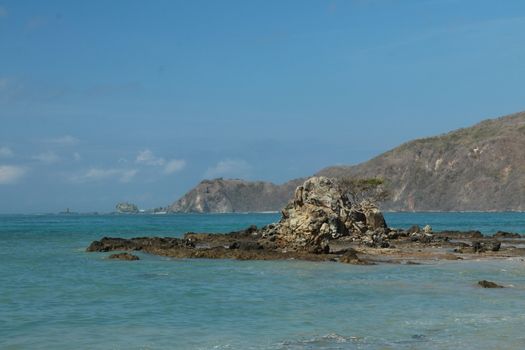 Rock formations on the beach Mandalika Kuta beach, Lombok, Indonesia. Blue sky and suuny day.