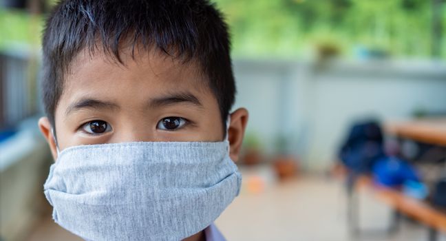 Close-up portrait Of a cute boy Wearing protective mask And he is looking at the camera.