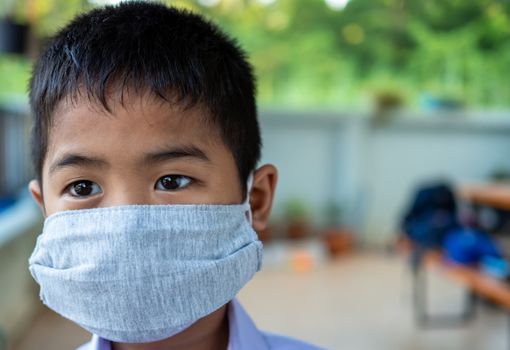 Close-up of a cute boy wearing a protective mask and he is looking at something.