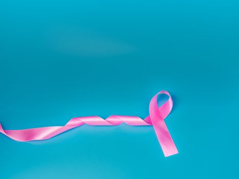 Pink ribbon On a blue background Conveys the awareness of cancer. World cancer day concept.