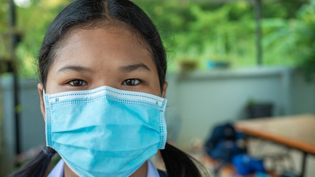 Close-up portrait Of a cute girl Wearing protective mask And he is looking at the camera