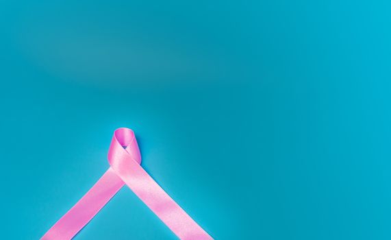 Pink ribbon On a blue background Conveys the awareness of cancer. World cancer day concept.