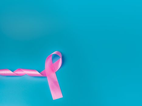 Pink ribbon On a blue background Conveys the awareness of cancer. World cancer day concept.