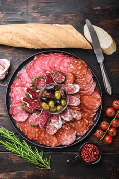 Dry cured sausage sliced -chorizo, fuet, salami on wooden table, flat lay.