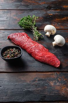 Tri tip steak with fresh seasoningsm thyme, organic tri-tip roast with fat marbled through the meat ready to roast or barbecue on wooden background, top view space for text.