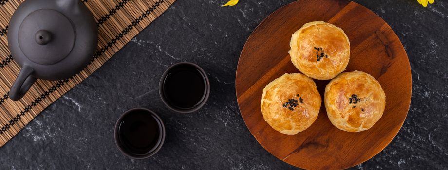 Moon cake yolk pastry, mooncake for Mid-Autumn Festival holiday, top view design concept on dark wooden table with copy space, flat lay, overhead shot