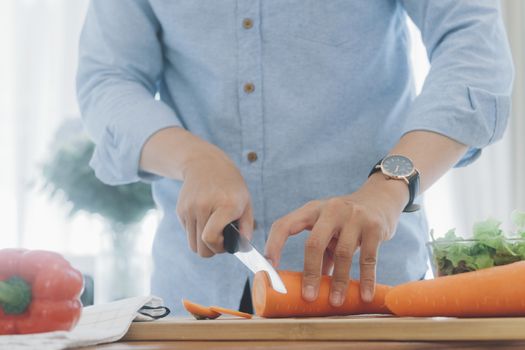 Man preparing delicious and healthy food in the home kitchen.