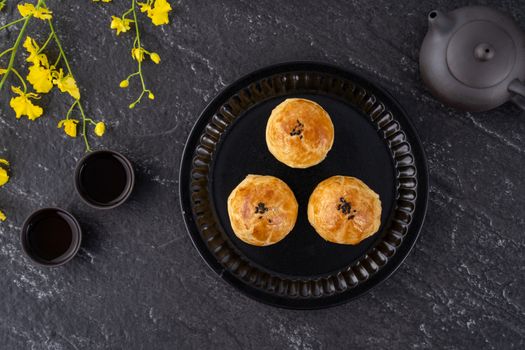 Moon cake yolk pastry, mooncake for Mid-Autumn Festival holiday, top view design concept on dark wooden table with copy space, flat lay, overhead shot