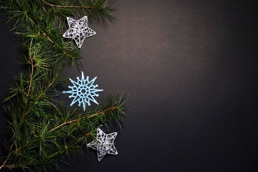 coniferous branches and Christmas tree decorations on a New Year's black background, copy space