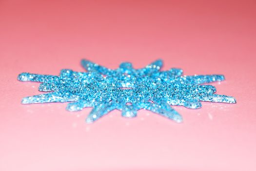 blue snowflake on pink background, copy space for christmas background.