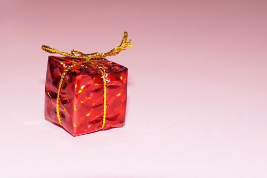 shiny red gift box on pink background, copy space