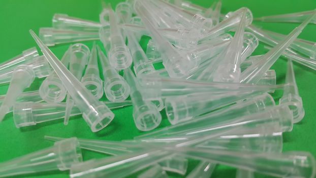 Close up view of micro litre tips on green floor sheet with empty holes. Reseach lab. tool for accurate measurement.