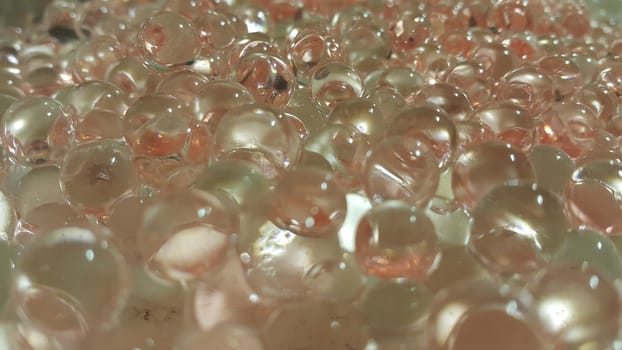 Closeup view with selective focus of shiny glittering orbeez or colorful water balls hydrogel. Water beads orbeez background.