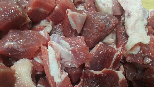 Close up view of fresh finely chopped meat cubes. Red meat small steaks with whitish meat fat.