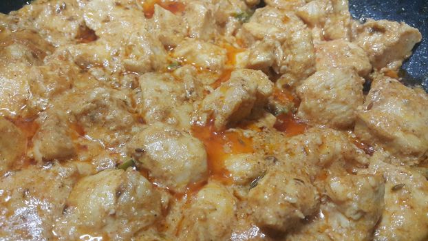 A close up view of stewed chicken meat cubes with spices on it, a traditional home made delicious chicken meat dish