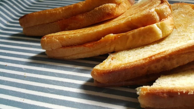 Closeup view of freshly prepared half fried slices of toast bread. Food background for bakery products