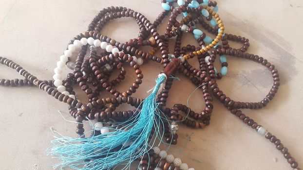 Beautiful wooden prayer beads or rosary placed over fabric background. Religion concept of ramadan or Eid for muslims.