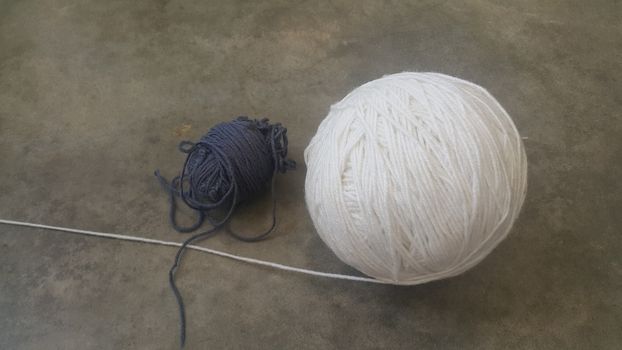 Colorful ball of threads wool yarn for knitting on grey floor background