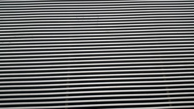 Close up view of shiny metal stripes background of interior walls and floor texture. The metal stripes repeatedly arranged to make wall or floor design.