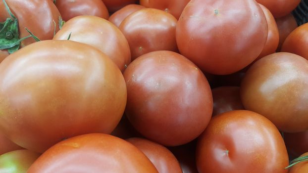 Red tomatoes in red basket in market for sale. A fruit background for text and advertisements