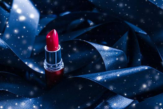 Red lipstick on blue silk and shiny glitter background, luxury make-up and beauty cosmetics