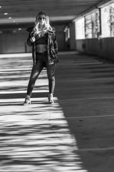 A gorgeous blonde model poses in a parking deck on an autumn day