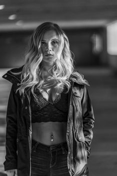 A gorgeous blonde model poses in a parking deck on an autumn day