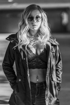 A gorgeous blonde model poses in a parking deck on an autumn day