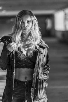 A gorgeous blonde model poses in a parking deck on an autumn day