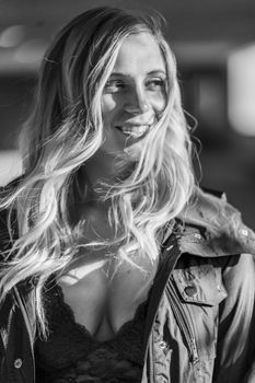 A gorgeous blonde model poses in a parking deck on an autumn day