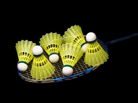 Badminton racket wit six yellow shuttlecock isolated on black side view