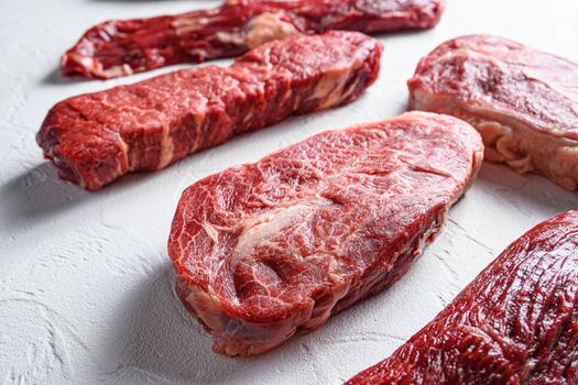 Raw organic top blade in front of machete denver cuts marble beef on white backgroundclose up new wide angle selective focus.