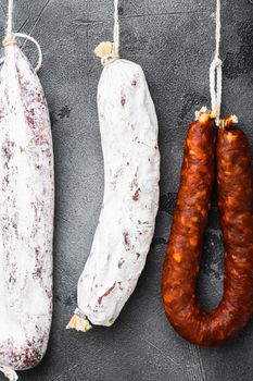 Spanish salami from a rack at market on grey textured background, flat lay.