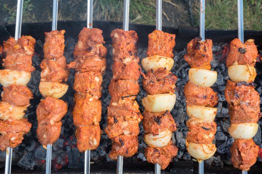 Photo cooking fry shish kebab,BBQ, barbecue, shashlik or meat on coals. Cooking meat in the grill on skewers in nature in the summer on a picnic. Pork on the grill