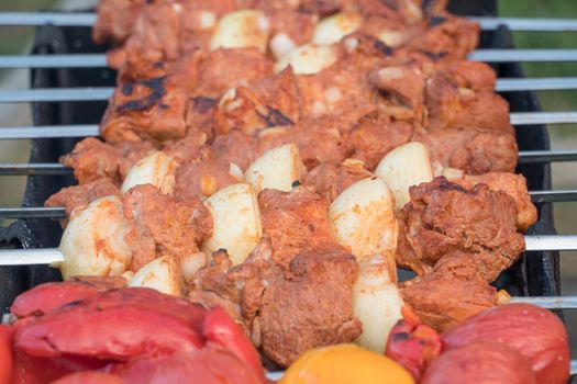 Photo cooking fry shish kebab,BBQ, barbecue, shashlik or meat on coals. Cooking meat in the grill on skewers in nature in the summer on a picnic. Pork on the grill