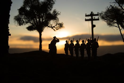 War Concept. Military silhouettes fighting scene on war fog sky background, World War Soldiers Silhouette Below Cloudy Skyline At sunset. Battle in ruined city. Selective focus