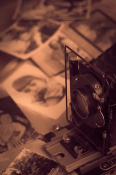 Old photos. Old camera on the background of photos. Toned photo. Photo album with photos from the last century.