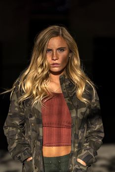 A gorgeous blonde model poses in a parking deck on an autumn day