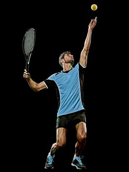 one caucasian young player tennis man in studio isolated on black background