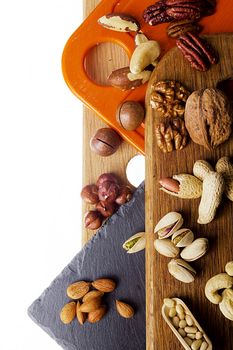 Mix of nuts on different cutting boards on a white background