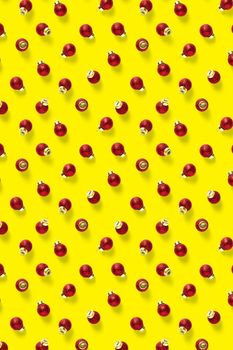 Christmas red decorations on yellow background. Christmas ornaments composition for background. Flat lay background madefrome red ornaments decorations