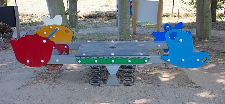 Modern colorful children playground in public park, seesaw