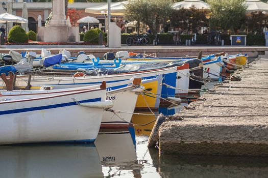 BARDOLINO, ITALY 16 SEPTEMBER 2020: Colored boats moored on Bardolino port in Italy