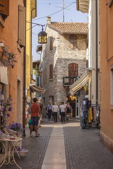 LAZISE, ITALY 16 SEPTEMBER 2020: Alley with people and tourists walking in Lazise in Italy