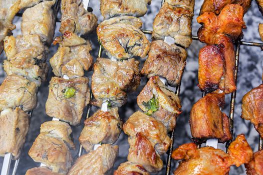 Russian shashlik with skewers on a round grill in Norway.