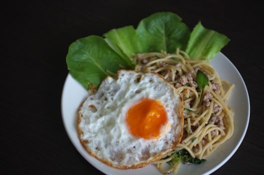 Spaghetti stir fried with Thai Basil spicy sauce with Fried egg  , fusion Thai style , space for text